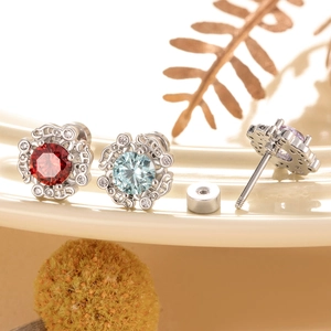 Silver flower stud earrings with red and blue crystals and screw-back detail