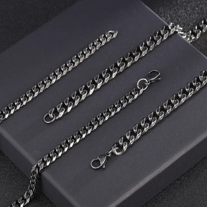 Classic silver stainless steel Cuban link necklace for men on a dark display stand