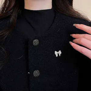 Elegant silver bow brooch with sparkling cubic zirconia on black tweed jacket for women