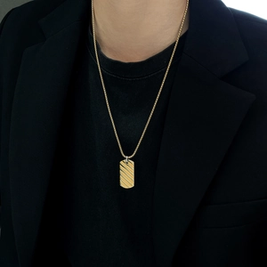Mens gold rectangle striped pendant necklace on model with black suit background