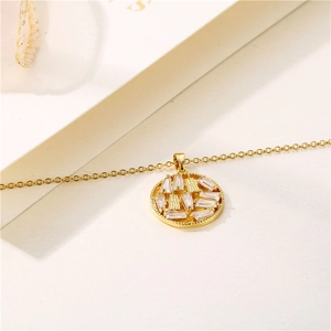 Collana dorata con pendente circolare con zirconi rettangolari su sfondo bianco