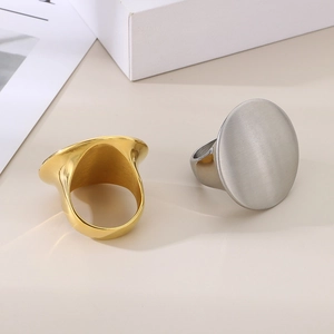Detailed view of large oval stainless steel rings in polished gold and brushed silver