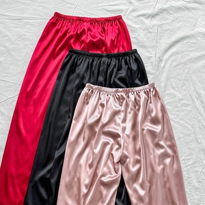 Loose satin lounge pants in red, black, and pink with elastic waist and silk texture