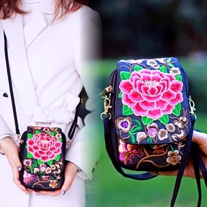 Detail showing intricate peony embroidery and adjustable strap on ethnic canvas bag