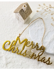 Close-up of golden glitter Merry Christmas wooden ornament in a snowy scene