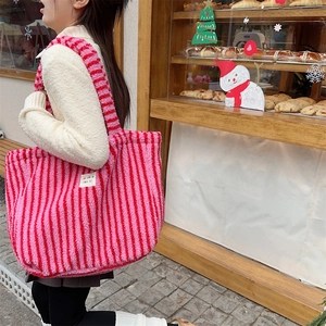 Détails de la texture du sac cabas en peluche rayé rose et rouge avec étiquette