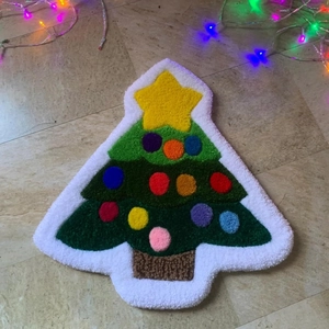Detailed plush texture of a green Christmas tree shaped rug with colorful ornaments