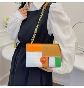 Detail of color-block shoulder bag with diamond pattern, chain strap, and orange lock