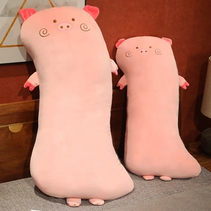Set of two soft pink plush pig bolster pillows in different sizes on a cozy bed