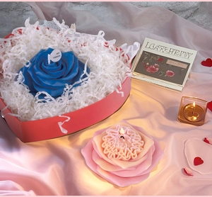 Detail of rose-shaped scented candles in blue and pink tones with realistic petal textures