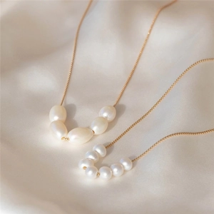 Detail of natural freshwater pearl necklace with adjustable gold Y-pendant on silk background