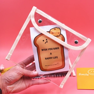 Detailed view of clear PVC pouch featuring metal snap buttons and cute toast illustration