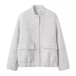 Detailed view of grey tweed jacket texture with front flap pockets and sequins