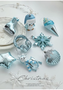Close-up of light blue Christmas ornaments including skates and penguins on a white plate