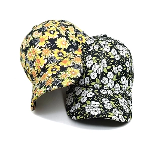 Black floral baseball caps with orange and white flower patterns in a stacked view