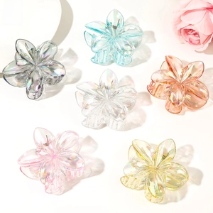 Macro shot of colorful floral acrylic hair clips with iridescent Aurora finish and metal spring