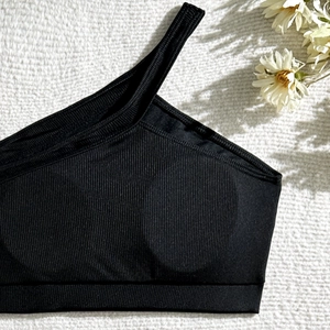 Detail shot of black ribbed one-shoulder bikini top with high-quality knit texture
