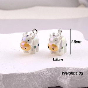 Macro view of pearlescent white cow charms with golden noses on white textured stones