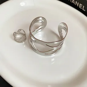 Minimalist irregular hollow silver bangle and open ring set with a sleek metallic finish