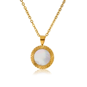 Detailed close-up of golden necklace pendant with white shell inlay and textured bezel