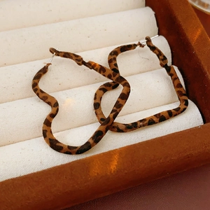 Detail of leopard print hoop earrings presented in a luxury jewelry display box