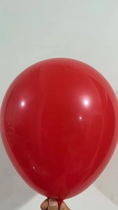 Close-up of a glossy red latex balloon inflated for Christmas party garland decoration