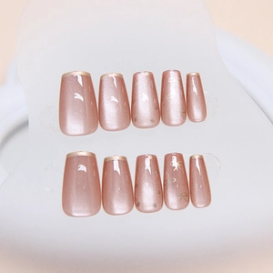 Faux ongles œil de chat or rose avec bords français et détails de nœuds dorés