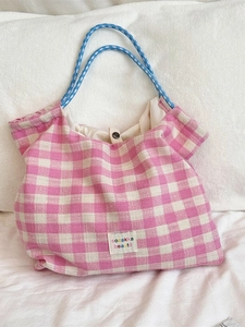 Pink and white checkered canvas tote bag with blue rope handles and logo label
