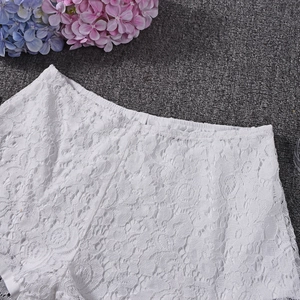 Close-up of white floral lace texture and intricate embroidery on fashionable women's set