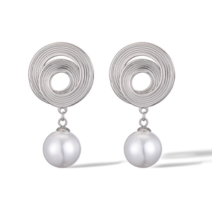 Close-up of geometric spiral earrings in silver with a large white hanging pearl detail