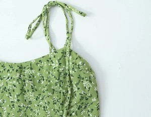 Détail de la bretelle florale ajustable sur une robe d'été verte en crêpe