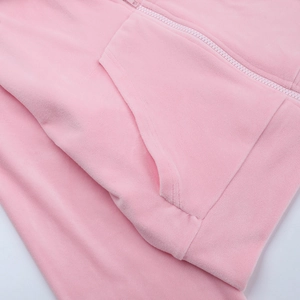 Dettaglio ravvicinato della cerniera e cuciture della felpa con cappuccio in velluto rosa