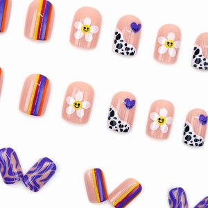 Colorful press-on nails with daisy smiles, cow prints, and wavy striped patterns set