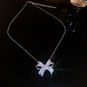 Elegant silver bow pendant necklace with zircon micro-pave on a black background