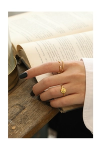 Detailed shot of three vintage gold rings with zircons and sun relief on a warm retro background