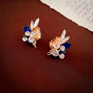 Detailed close-up of champagne teardrop crystal earrings with gold finish and rhinestones