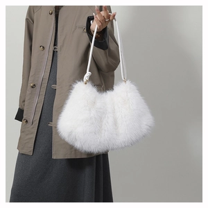 Gros plan d'un sac à bandoulière blanc en fausse fourrure avec détails dorés sur un mannequin
