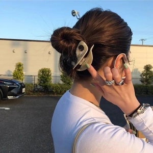 Elegant marble white hair claw clip styled with vintage silver rings and layered bracelets