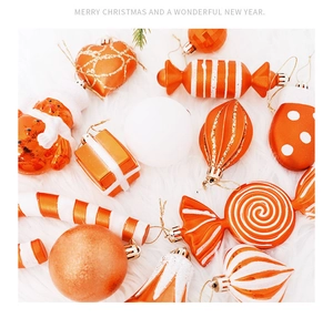 Close-up of orange and white assorted Christmas ornaments on a soft white plush background