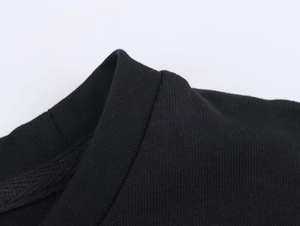 Dettaglio del girocollo nero e della cucitura in pizzo ad alta densità sulla maglietta