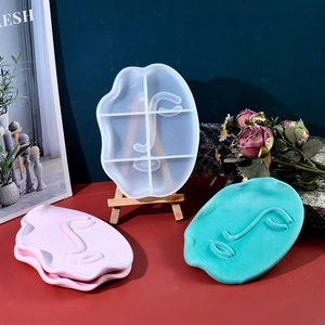 Dettaglio macro dello stampo in silicone viso astratto e vassoi in resina rosa e blu