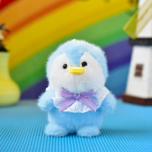 Detail view of a cute blue penguin plush toy keychain with a purple bow and white lace collar