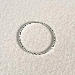 Macro detail of S925 sterling silver ring with faceted diamond-cut texture surface
