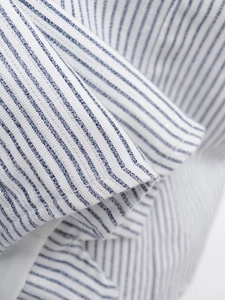 Vue macro détaillée du tissu en lin blanc à rayures bleues avec de légères touches argentées