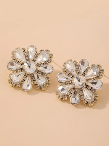 Macro detail of luxury flower stud earrings with sparkling crystals and gold finish