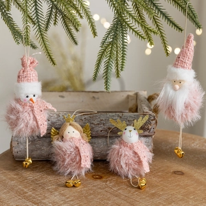 Pink plush Christmas ornaments set with dolls and golden bells on festive background