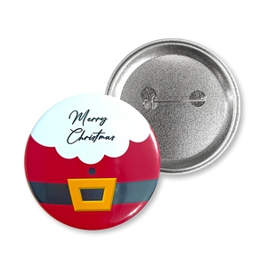 Detail of Christmas tinplate badge featuring Santa suit design and metal safety pin back
