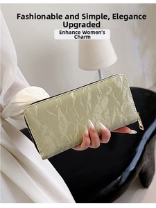 Close-up of mint green velvet long wallet with textured pleats and golden zipper