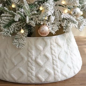 Detail of white cable knit Christmas tree skirt with soft texture and 3D woven patterns
