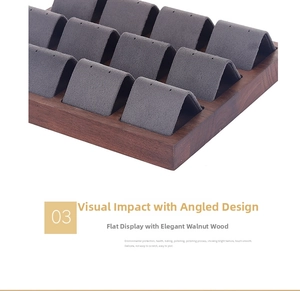 Macro detail of walnut wood jewelry tray with 12 slots and grey velvet display surface